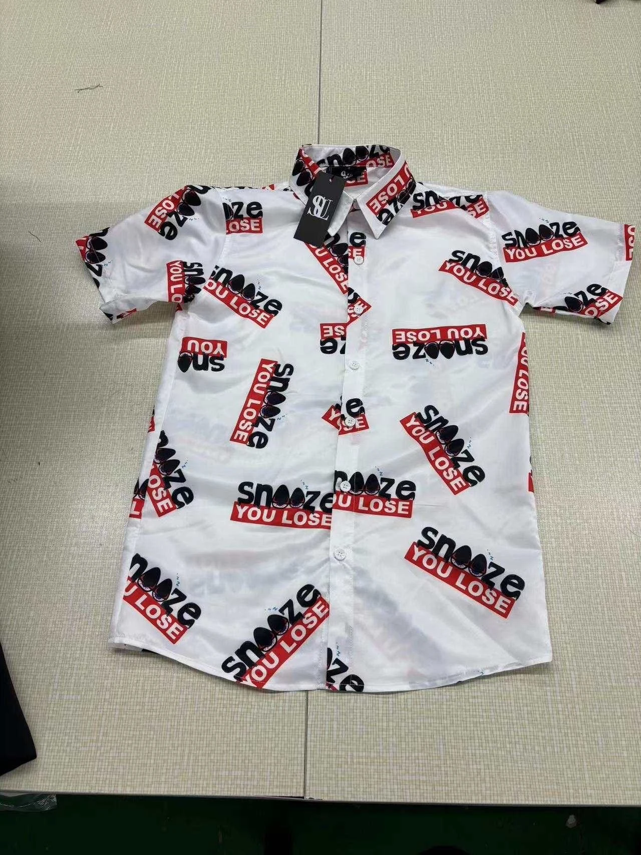 White short sleeve SUL button-up shirt with repeating red and black lettering